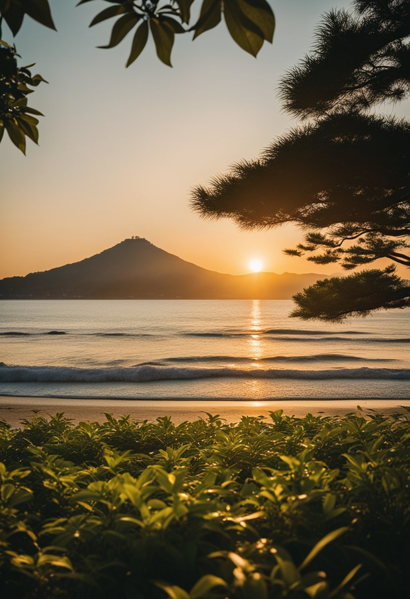 The sun sets over Enoshima Beach, casting a warm glow on the sandy shore and calm waves. Surrounded by lush greenery, it is one of Japan's best beaches